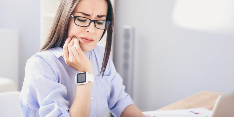 young business woman with toothache in need of root canal therapy