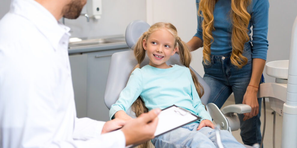 family at the dentist office, speaking with dentist