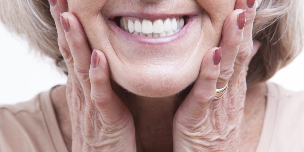 older woman with natural looking dentures smiling