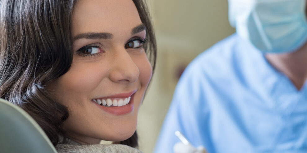 Smiling young woman receiving dental checkup with dentist