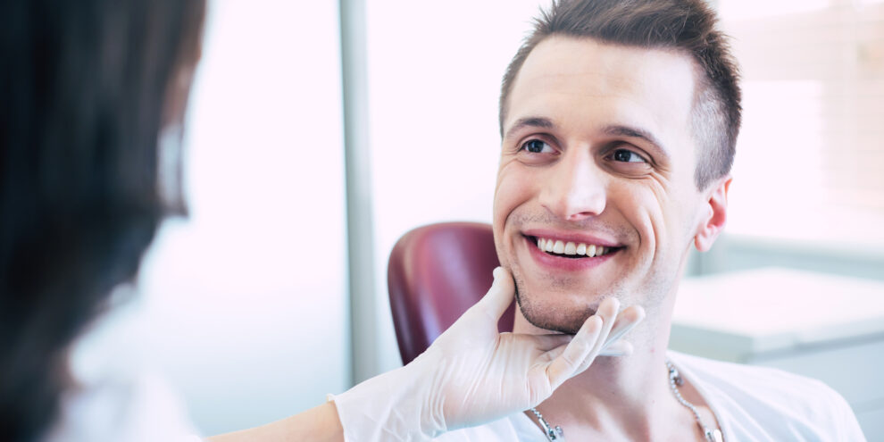 image of a man smiling and having his teeth inspected by a caring Marlow Dentist
