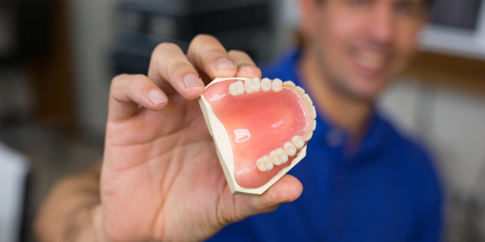 man presenting realistic dentures