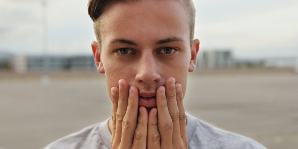 nervous man holding hands to face