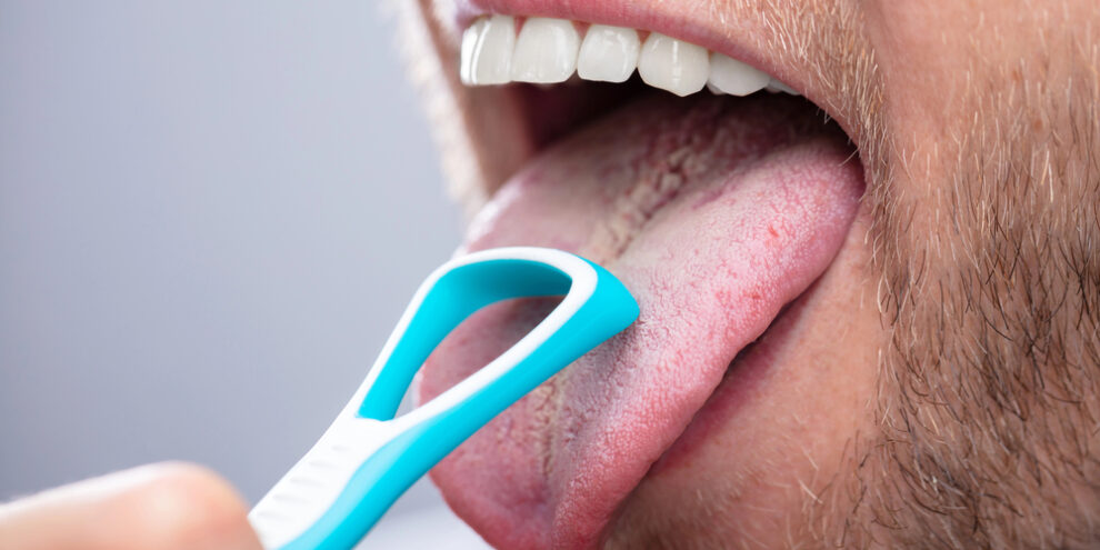 Man using tongue scraper to fight bad breath