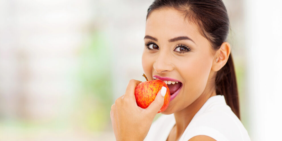 beautiful young woman eating an apple