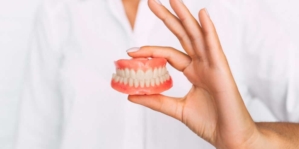 dentist holding dentures