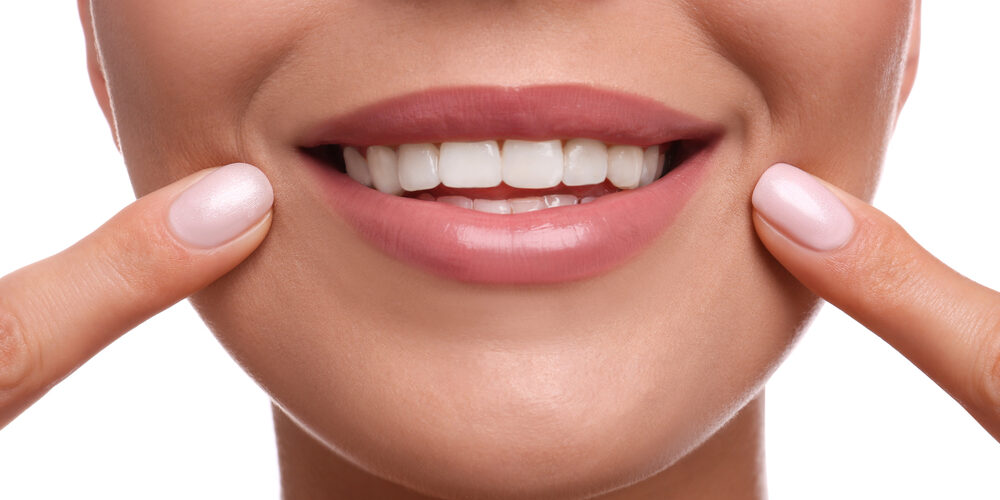 close up of woman's smile after cosmetic dentistry on white background