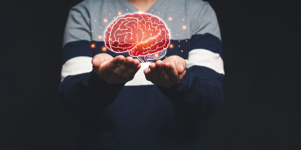 man holding generated image of brain in the palms of his hands