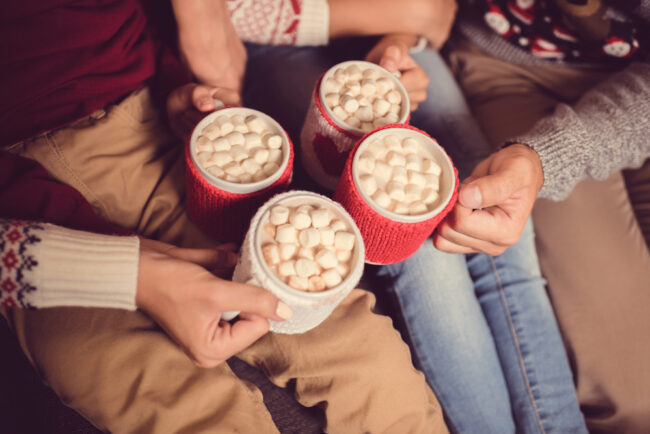 family holding mugs with hot cocoa