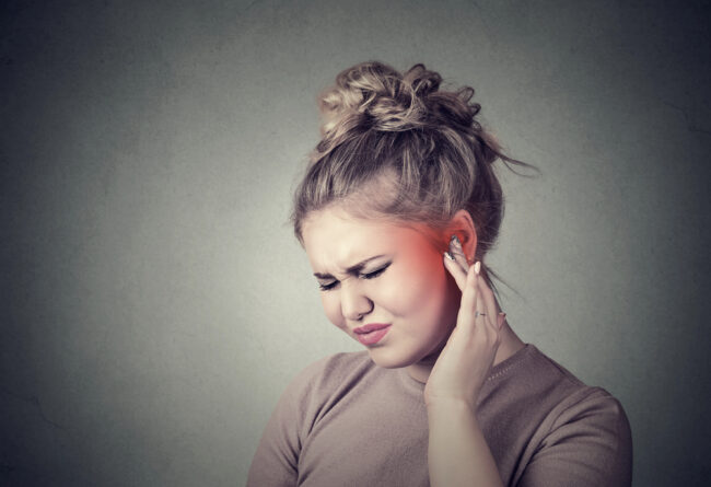 woman suffering from ear pain because of teeth grinding