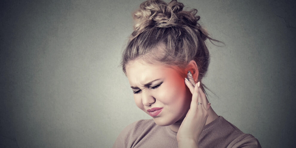 woman suffering from ear pain because of teeth grinding