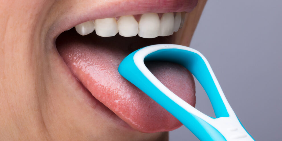 woman using a tongue scraper for bad breath