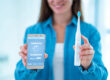 woman holding an electric toothbrush with a phone app